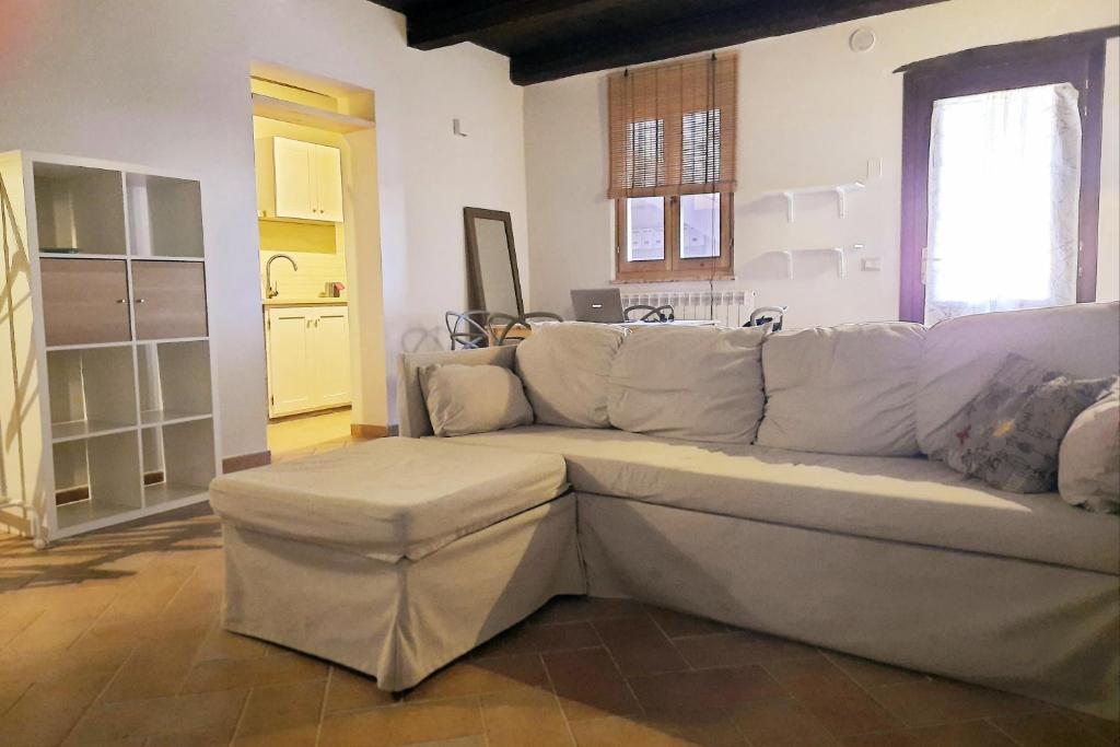una sala de estar con un sofá blanco en una habitación en Appartamento di Claudia in campagna, Locazione turistica, en Spoleto