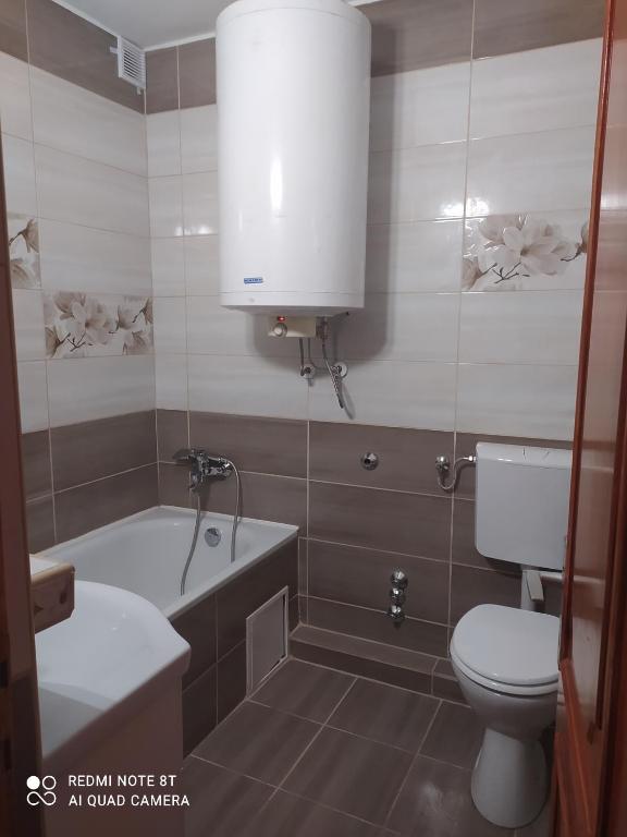 łazienka z toaletą, wanną i umywalką w obiekcie Apartmanház Gabriella w mieście Harkány