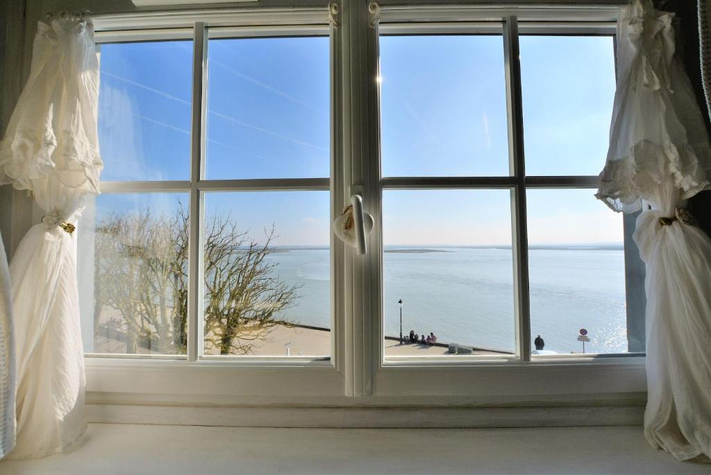 uma janela com vista para a praia em Les Mouettes Blessées em Le Crotoy