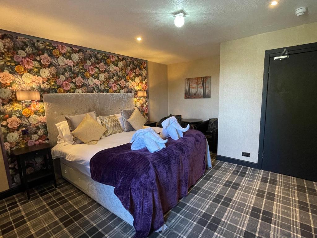 a bedroom with a bed with two teddy bears on it at The Albert Inn in Nairn