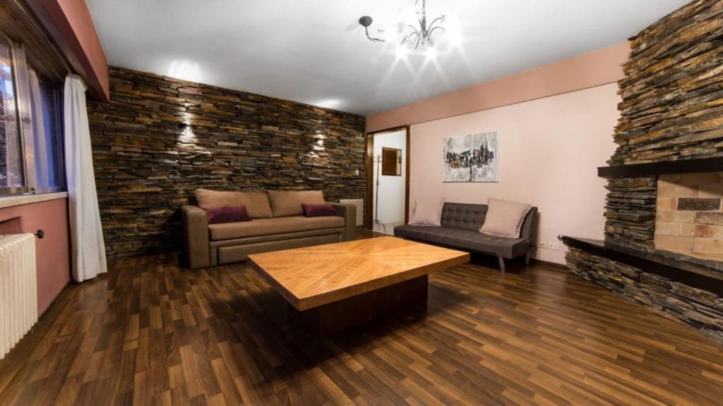 ein Wohnzimmer mit einem Sofa und einem Kamin in der Unterkunft Piso villegas in San Carlos de Bariloche