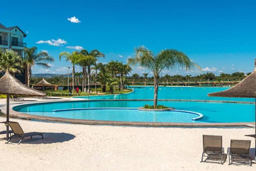 a large swimming pool with chairs and palm trees at Insaka 3 The Blyde Lagoon Experience in Pretoria