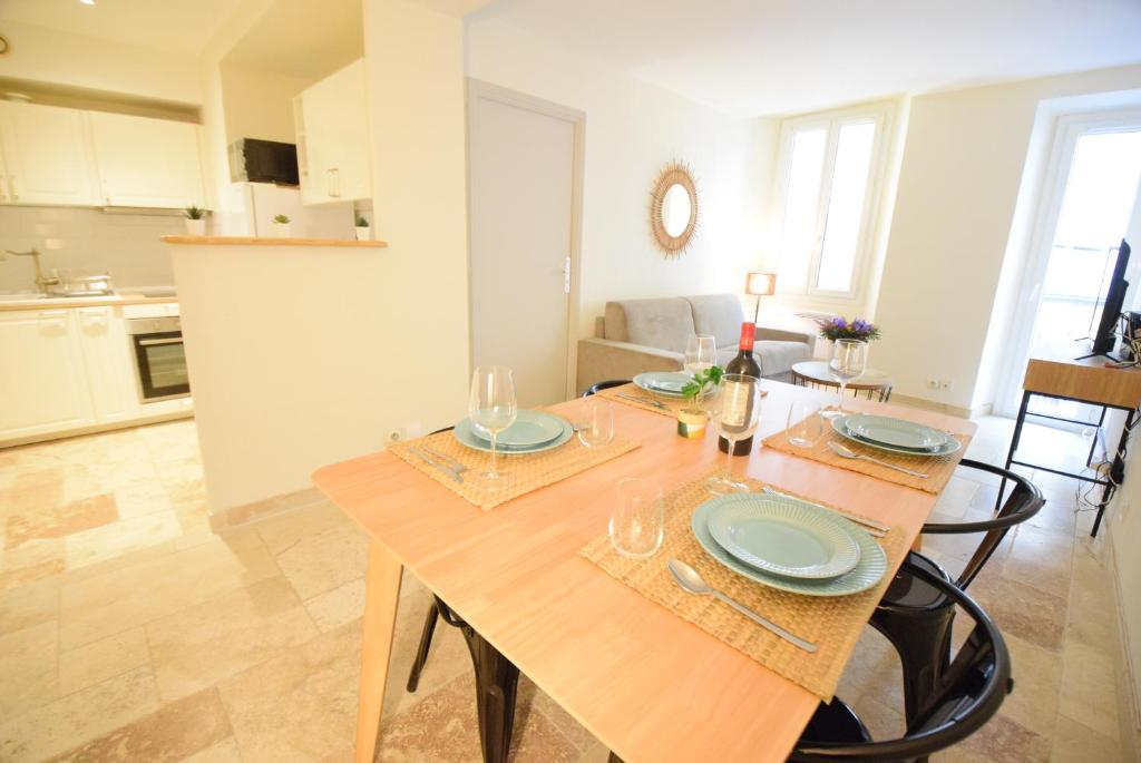 une salle à manger et une cuisine avec une table en bois dans l'établissement Nice Renting - PAIROLIERE - SPACIOUS FLAT - OLD NICE - MASSENA - TERRACE, à Nice