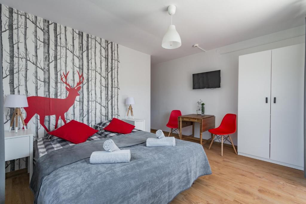 a bedroom with a large bed with red pillows at Willa Wiesia Rabka Zdrój in Rabka-Zdrój