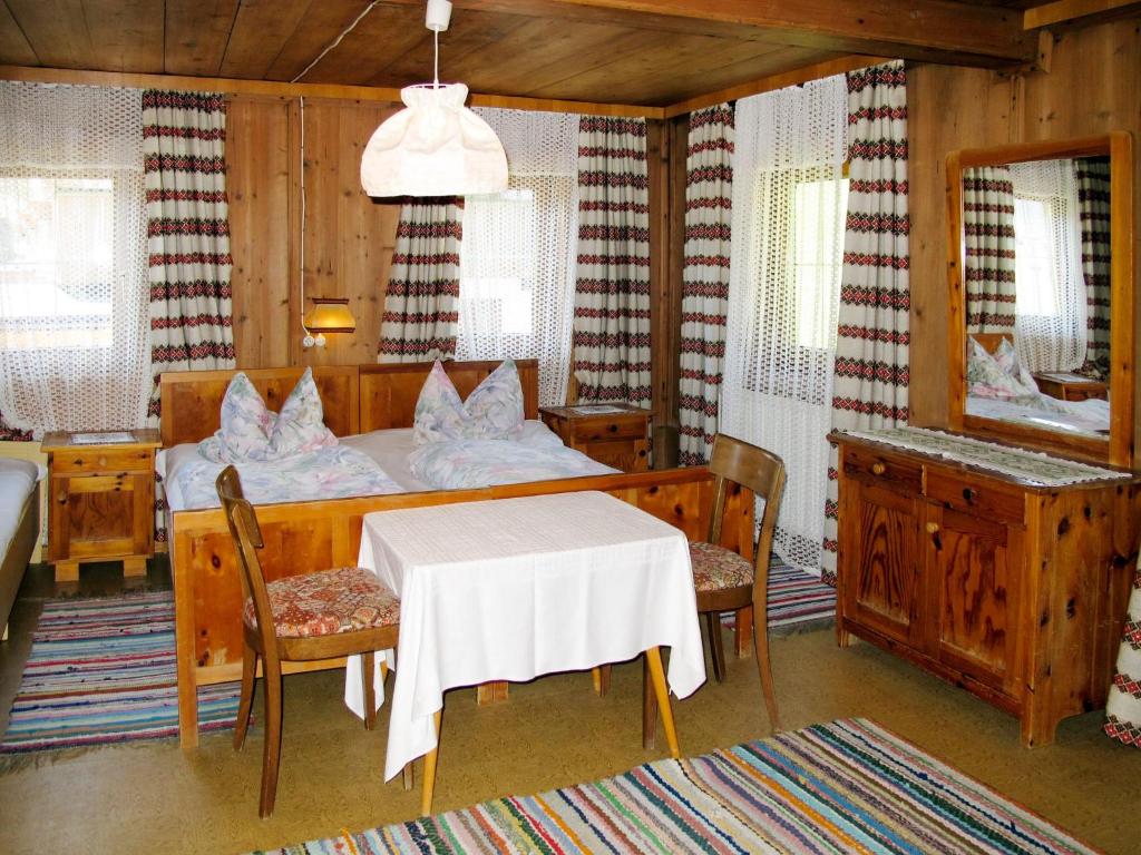 a bedroom with a bed and a table and chairs at Apartment Bauernhaus Schusterhäusl by Interhome in Schwendau