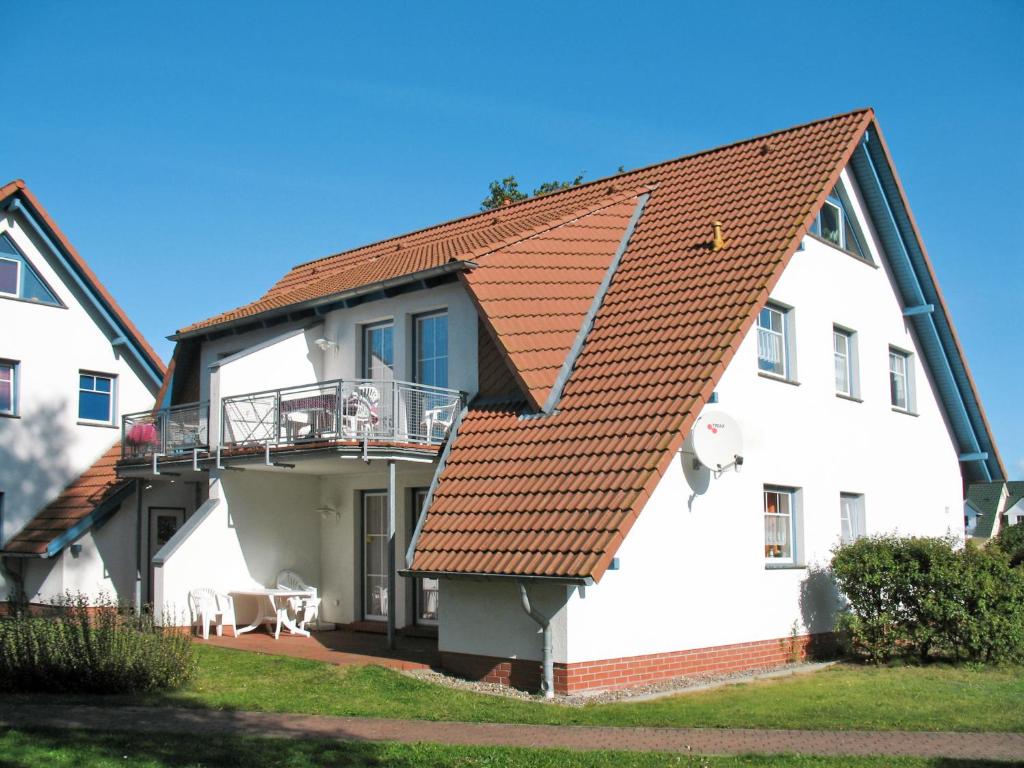 a white building with a red roof at Apartment Gartenstraße-1 by Interhome in Ostseebad Karlshagen