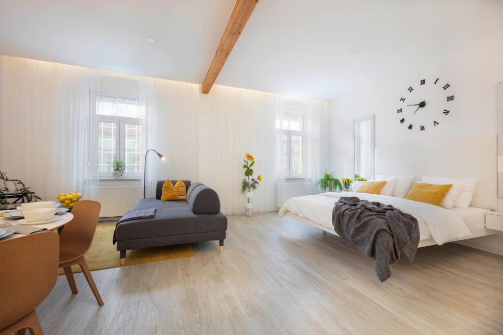 a white bedroom with a large bed and a clock at ALENKA's PLACE, fiber optic wi fi in Zagreb