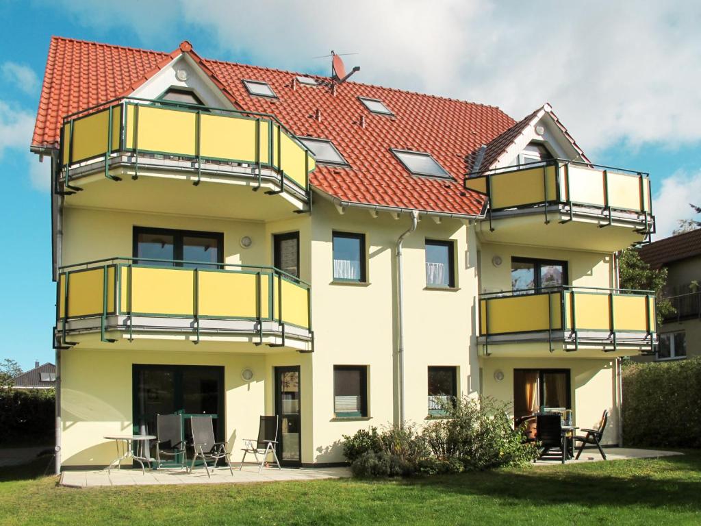 ツィノヴィッツにあるApartment Ostseetrio-1 by Interhomeの黄色いバルコニーと赤い屋根の家