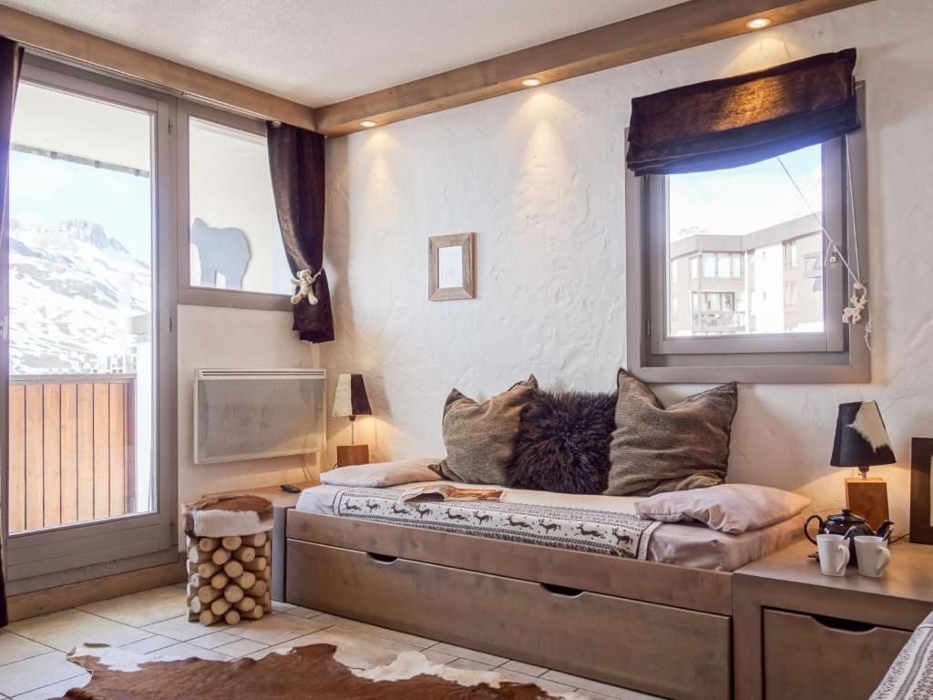 a large bed in a room with two windows at Apartment Plein Soleil-3 by Interhome in Tignes