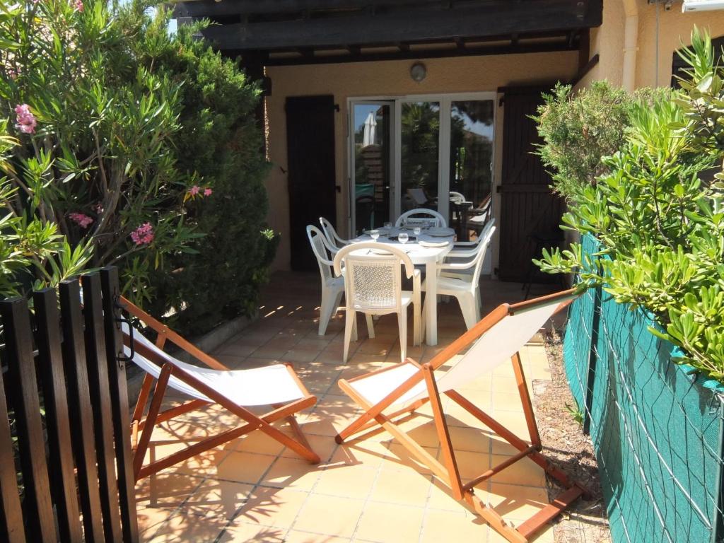 a patio with a table and chairs in a yard at Holiday Home Les Marines des Capellans by Interhome in Saint-Cyprien-Plage