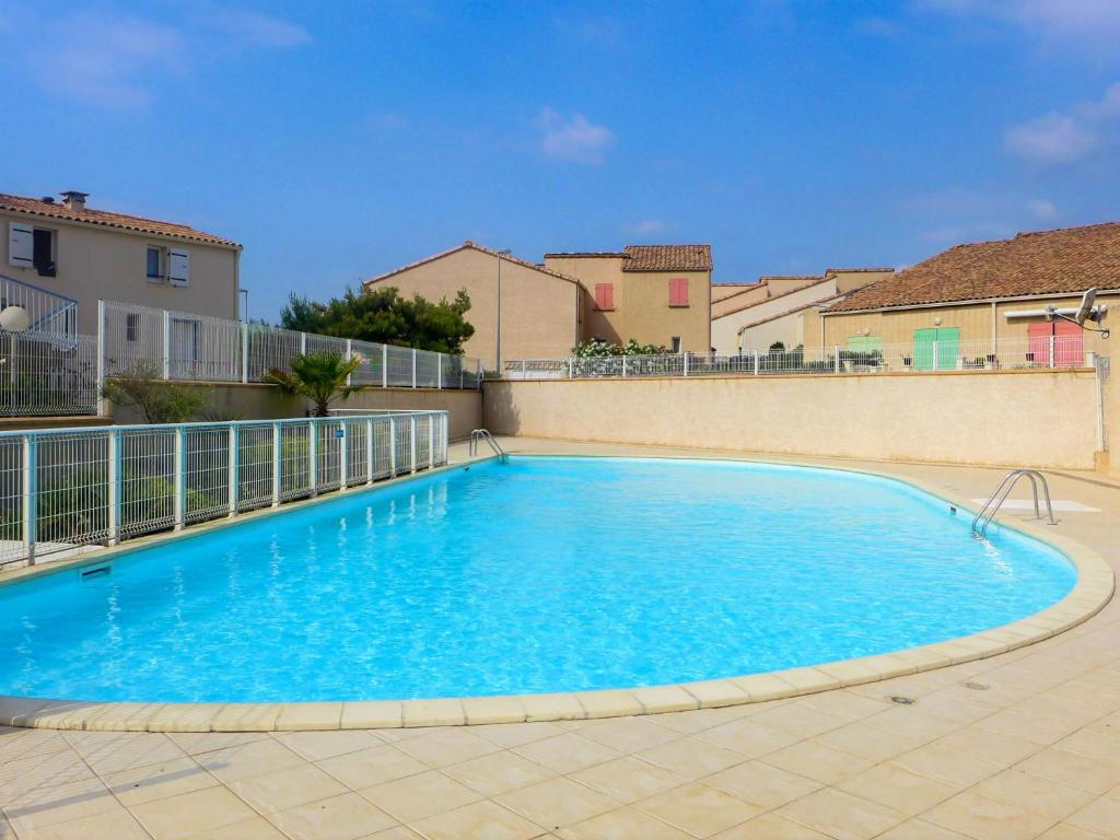a large blue swimming pool with a fence around it at Holiday Home Mer Indigo-3 by Interhome in Saint Pierre La Mer
