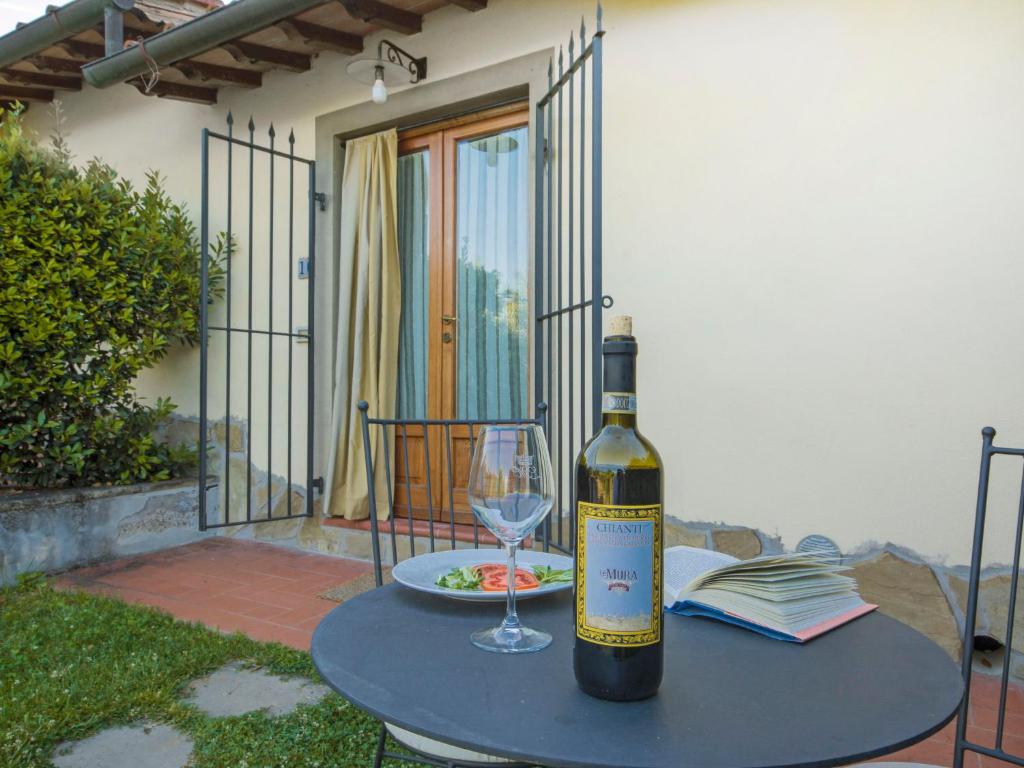 a bottle of wine sitting on a table with a glass at Apartment Simone by Interhome in Podere Panzano