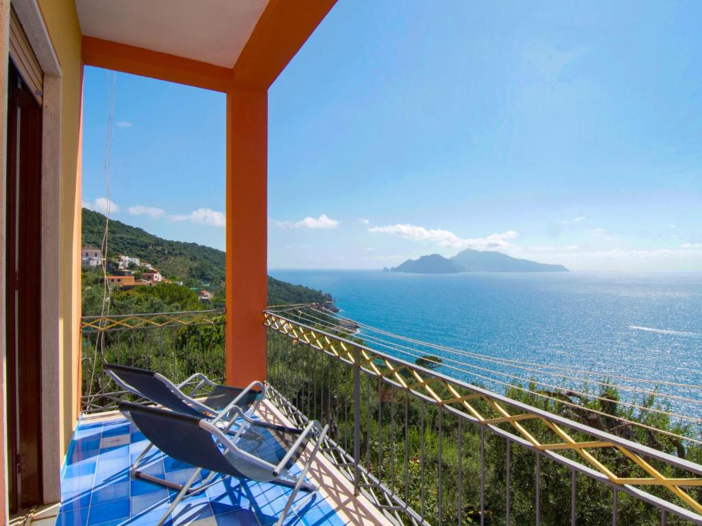 a balcony with a chair and a view of the ocean at Apartment Don Luigino - Capri view by Interhome in Massa Lubrense