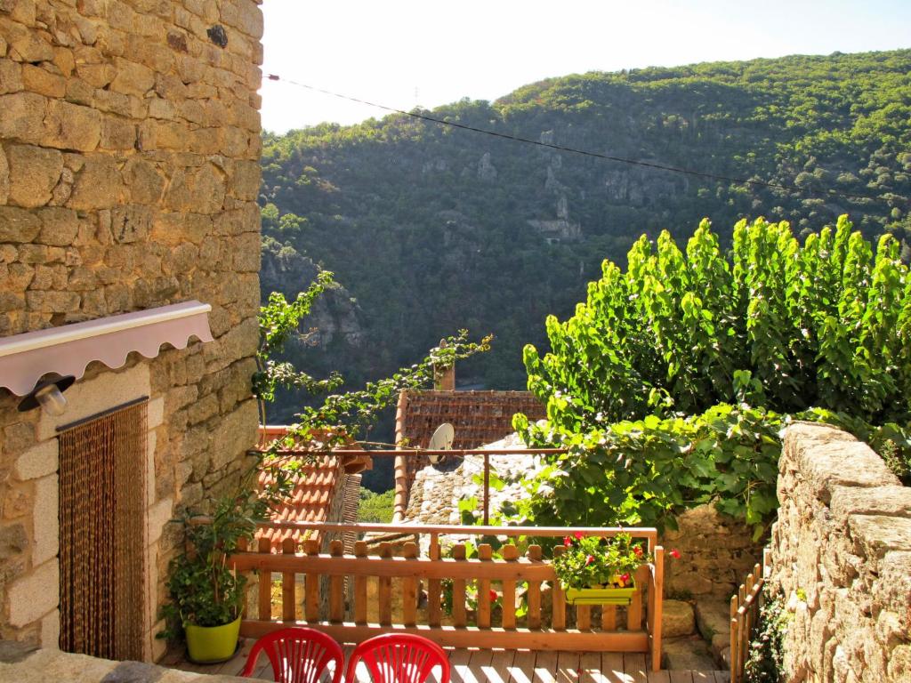 een balkon met rode stoelen en uitzicht op een berg bij Holiday Home Le Rouge Borne - LVS110 by Interhome in Sainte-Marguerite-Lafigère