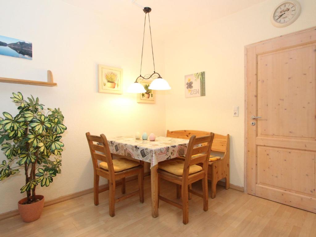 ein Esszimmer mit einem Tisch, Stühlen und einer Pflanze in der Unterkunft Apartment Am Birkenhain-28 by Interhome in Seefeld in Tirol