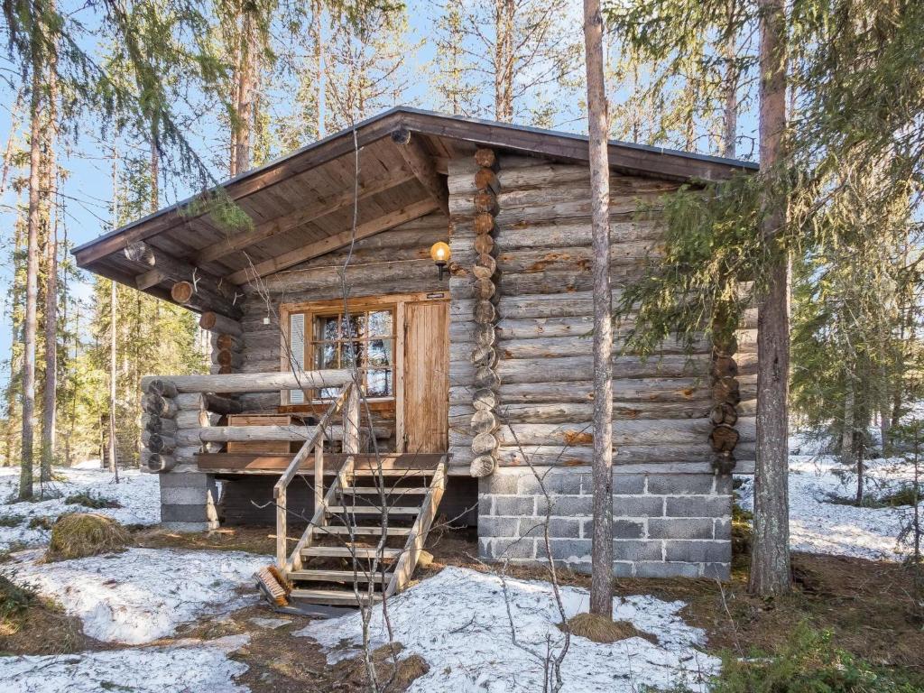 uma cabana de madeira com uma escada na floresta em Holiday Home Retkietappi honkapirtti by Interhome em Juuma