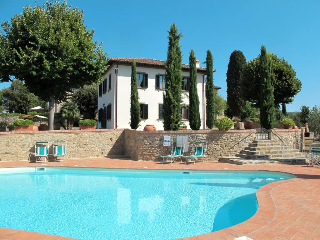 uma casa com piscina em frente a um edifício em Villa Le Gallozzole by Interhome em Quercegrossa