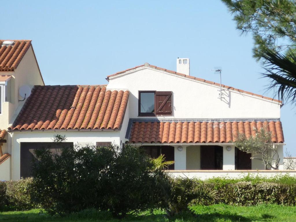 une maison blanche avec un toit rouge dans l'établissement Holiday Home Lotissement du Stade by Interhome, à Saint-Cyprien