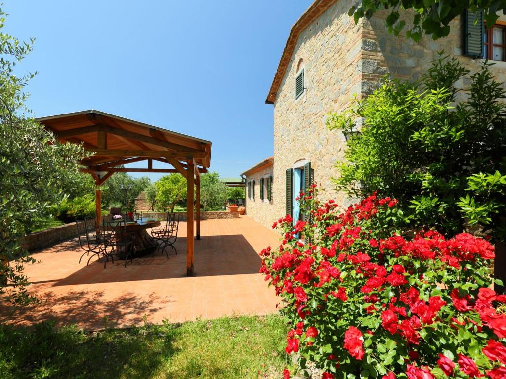 a patio with a table and flowers in front of a building at Holiday Home Lucia by Interhome in Cortona