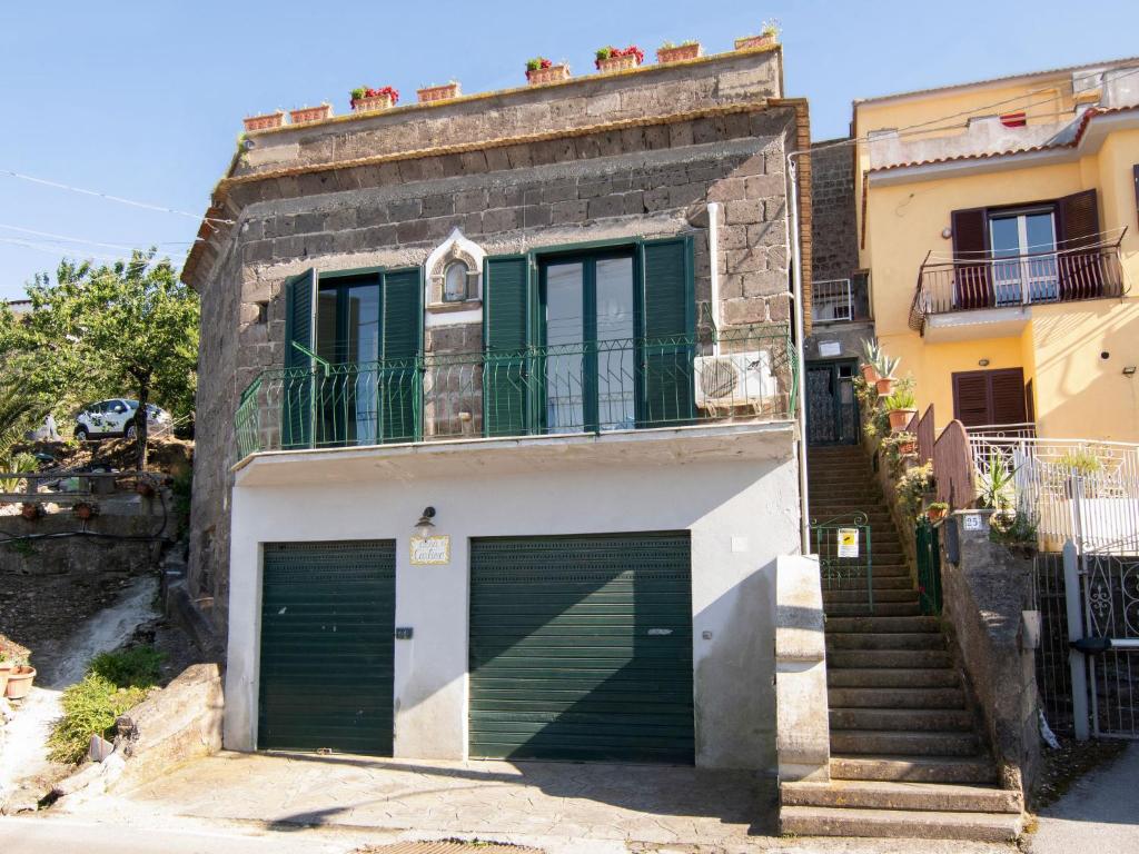 un edificio con due porte garage e un balcone di Apartment Carlino by Interhome a Nerano