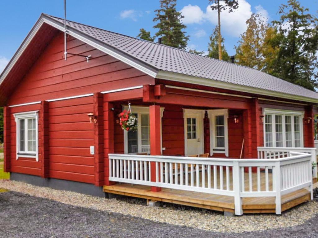 una casita roja con porche blanco en Holiday Home Kuikanranta by Interhome, en Hara