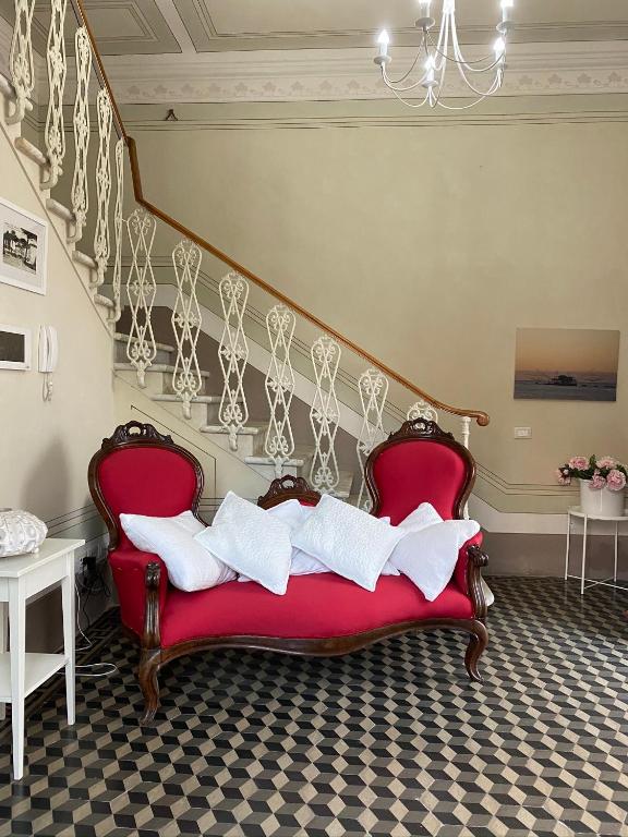a red couch with white pillows on it in a room at Villino Ermione in Marina di Pisa