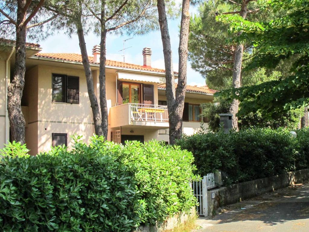 ein Haus mit einem Balkon und Bäumen davor in der Unterkunft Apartment I Pini by Interhome in Castiglioncello