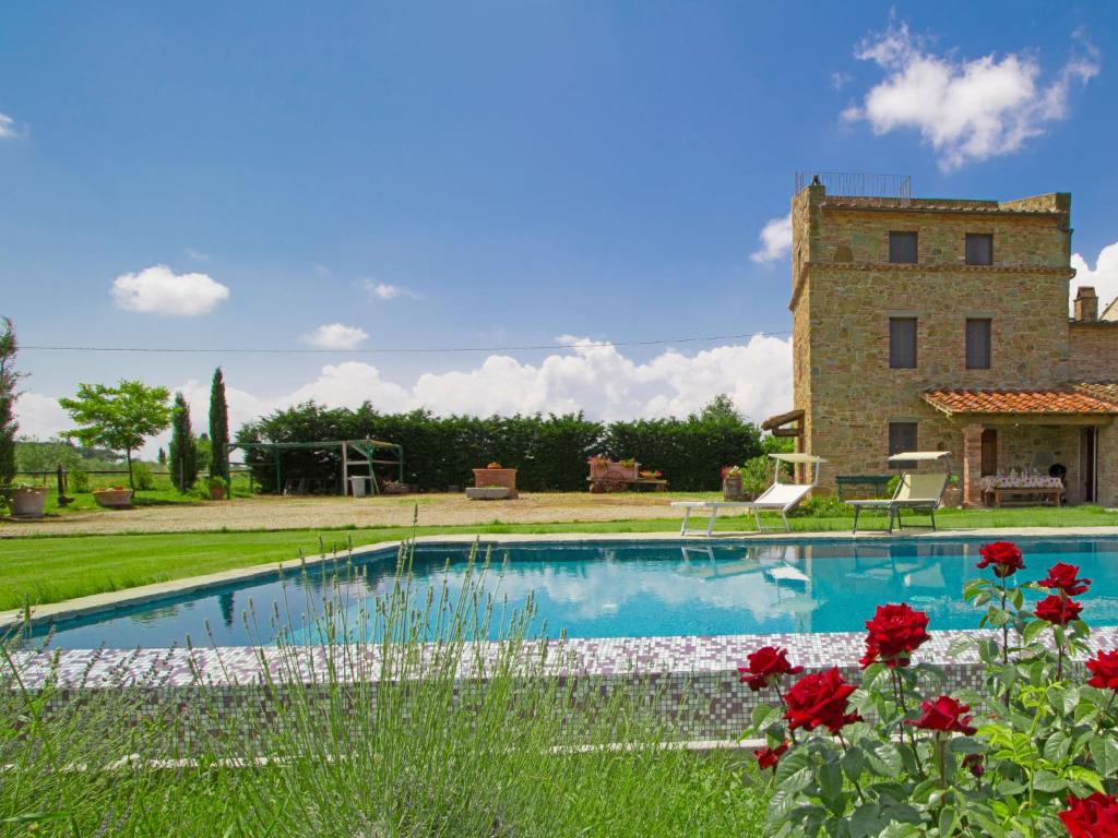 uma piscina em frente a um edifício com flores vermelhas em Holiday Home Il Loto by Interhome em Cortona