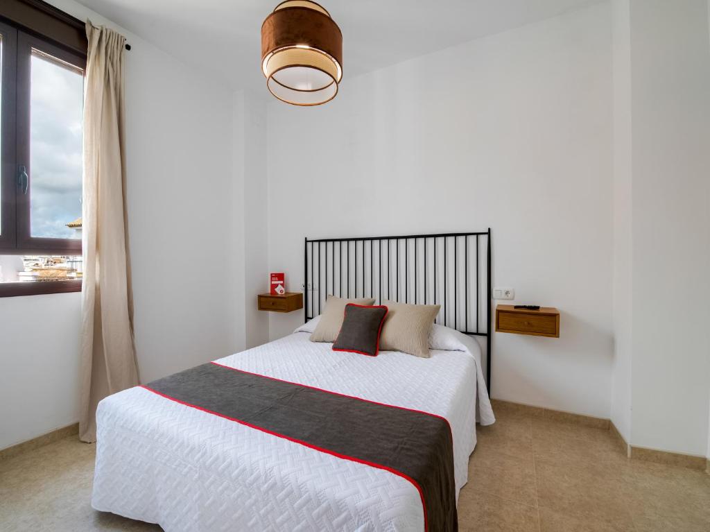 Posteľ alebo postele v izbe v ubytovaní Apartamentos Santiago