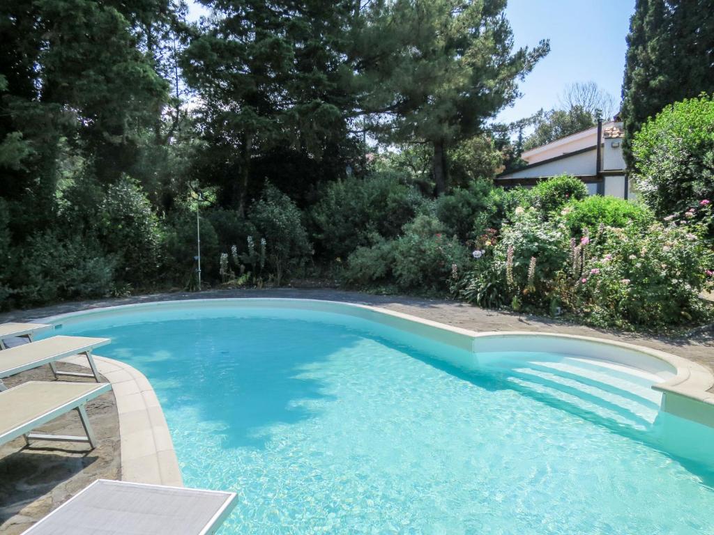 a swimming pool with blue water in a yard at Villa La Casa Vivente by Interhome in Livorno