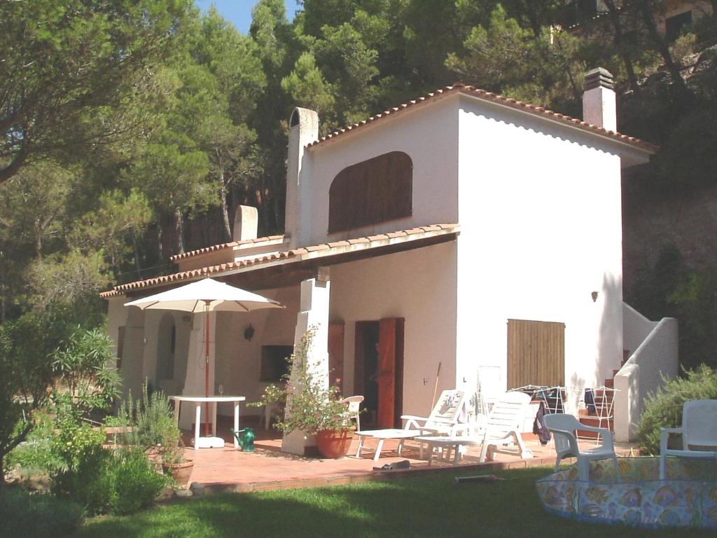 een wit huis met een patio en een parasol bij Beautiful detached villa close to sandy beach, shops and restaurants in Begur