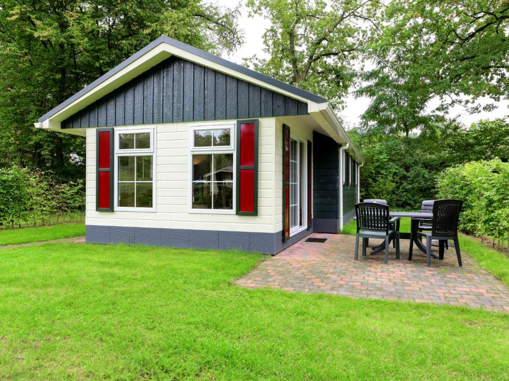 a small shed with a table and chairs in a yard at Holiday Home Buitenplaats Gerner-3 by Interhome in Dalfsen