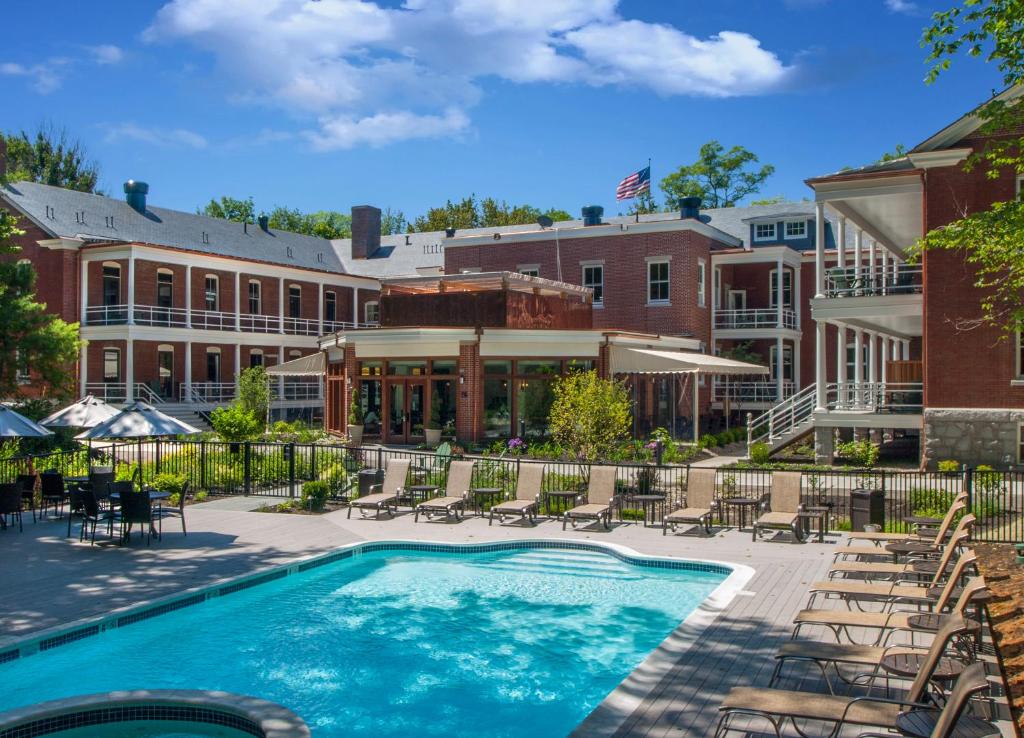 a pool at a hotel with chairs and a building at Inn at Diamond Cove in Great Diamond Island