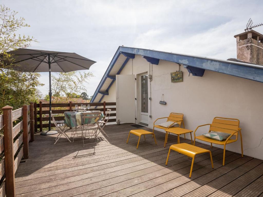une terrasse avec des chaises, des tables et un parasol dans l'établissement Apartment Les Choupou by Interhome, à Arcachon