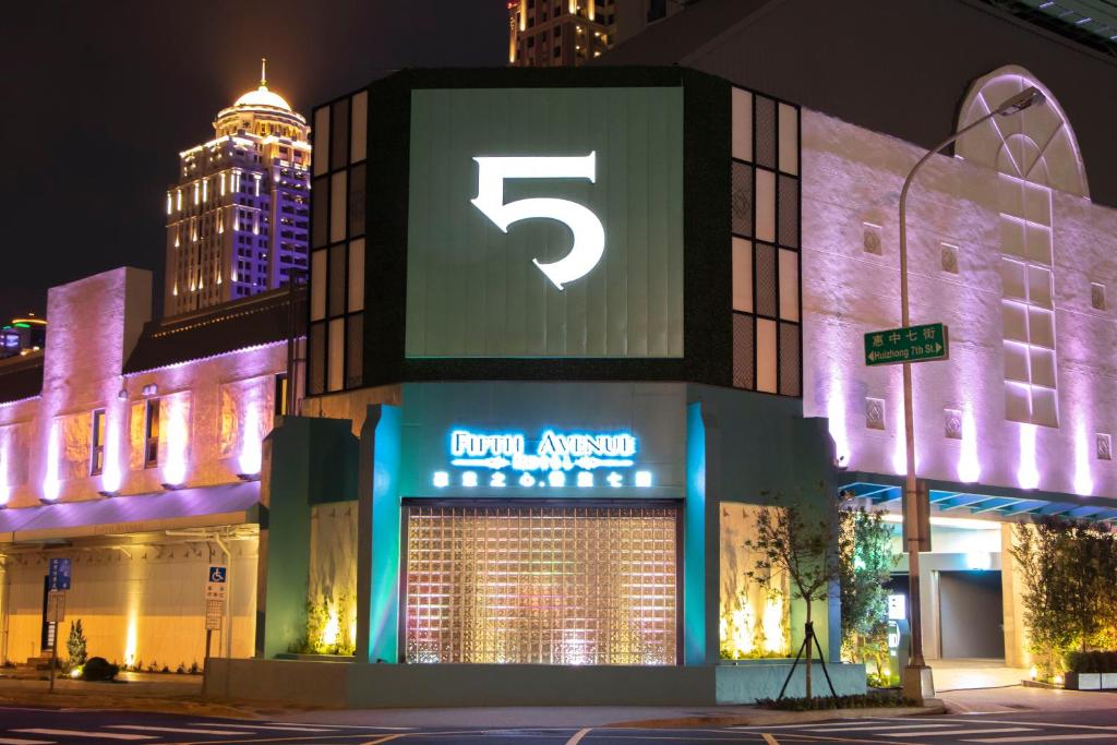 un bâtiment avec un panneau qui lit l'étonnement royal la nuit dans l'établissement Fifth Avenue Motel, à Taichung