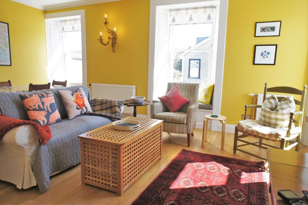 a living room with a couch and two chairs at 136 West Princes Street in Helensburgh