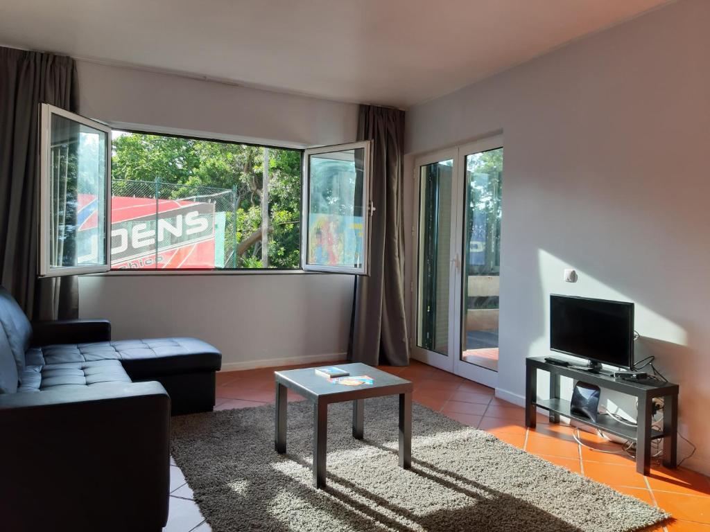 a living room with a couch and a tv at Apartamentos Matur Flats 2 in Machico