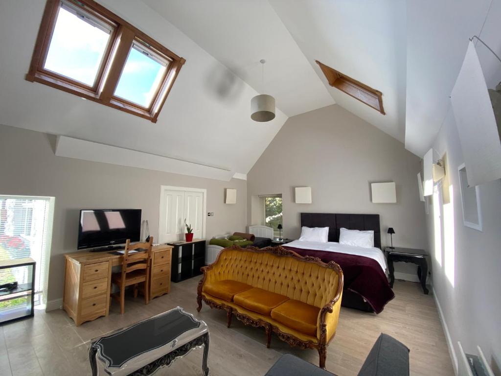 um quarto com uma cama, um sofá e uma televisão em Toadhall Rooms em Muchalls