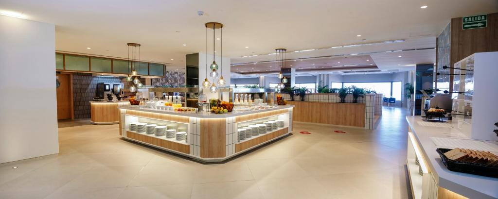 a restaurant with a counter with drinks on it at Hotel Cristina by Tigotan Las Palmas - Adults Only in Las Palmas de Gran Canaria