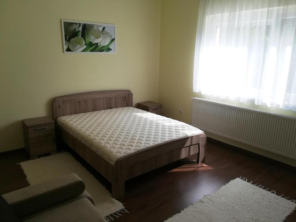mała sypialnia z łóżkiem i oknem w obiekcie Kurucz Vendégház Hajdúszoboszló w Hajduszoboszlo