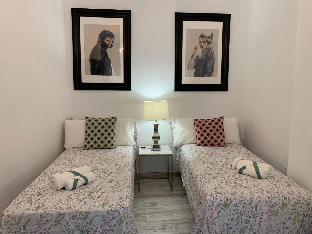 2 Betten in einem Zimmer mit 2 Bildern an der Wand in der Unterkunft DREAM SMILE in Santa Cruz de Tenerife
