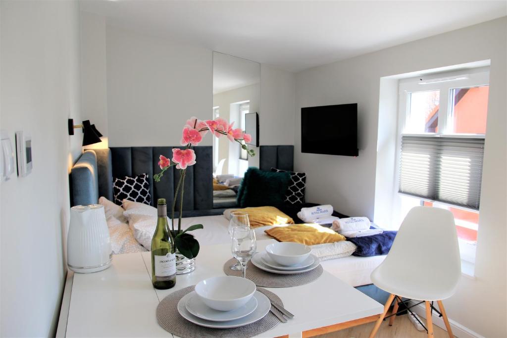 a white living room with a table and chairs at Apartamenty Royal Maris 5 - pokój dwuosobowy, najlepsza lokalizacja w Ustce, blisko plaży i portu, bezpłatny parking, ścisłe centrum in Ustka