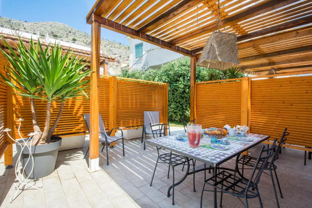 a patio with a table and chairs under a pergola at Villa Cinzia-150 mt from the beach in Mondello