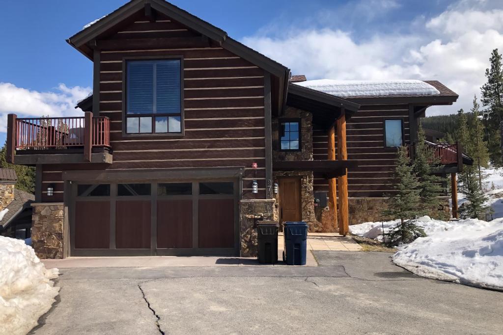 a log house with a garage in the snow at Slopeside Sanctuary in Copper Mountain