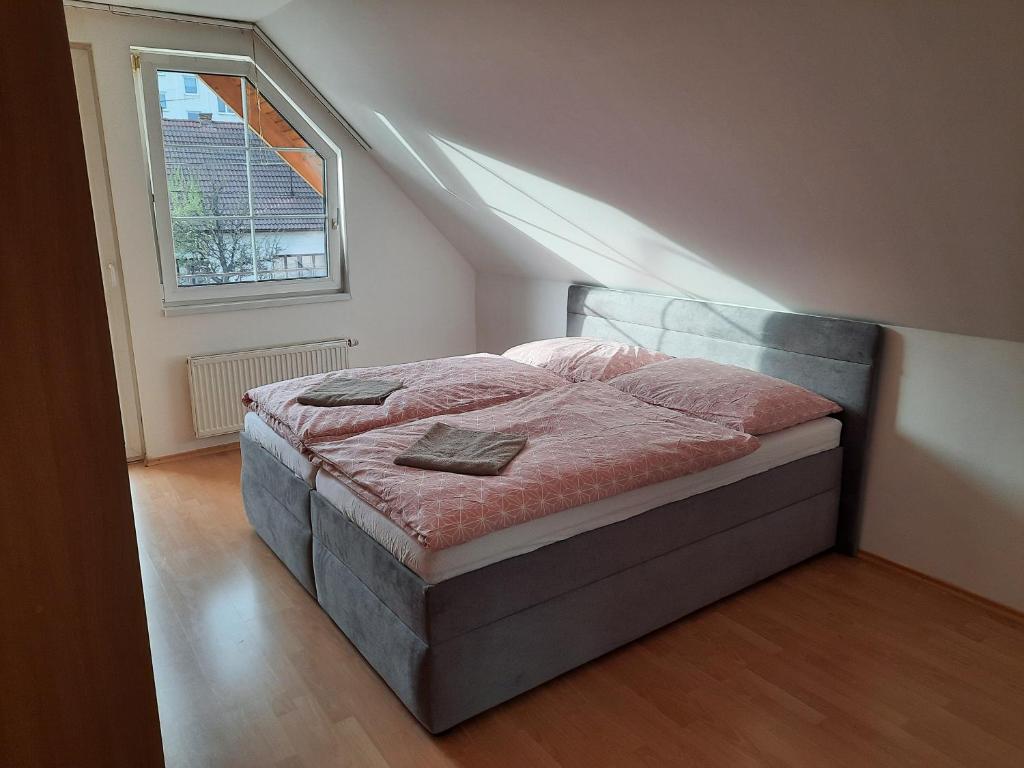 1 dormitorio con cama y ventana en el ático en Apartmán Chiarita, en Nemšová