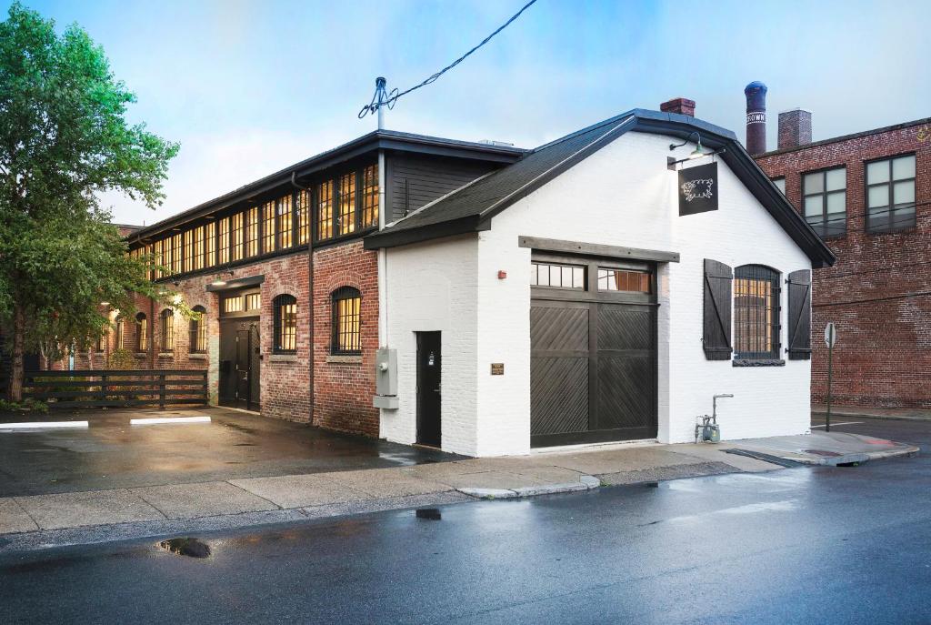 a white building with a garage on a street at Dye House in Providence