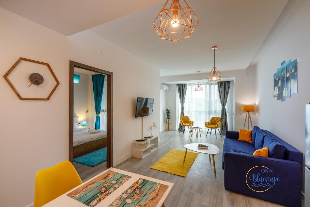 - un salon avec un canapé bleu et une table dans l'établissement Onix Bluescape, à Mamaia Nord – Năvodari