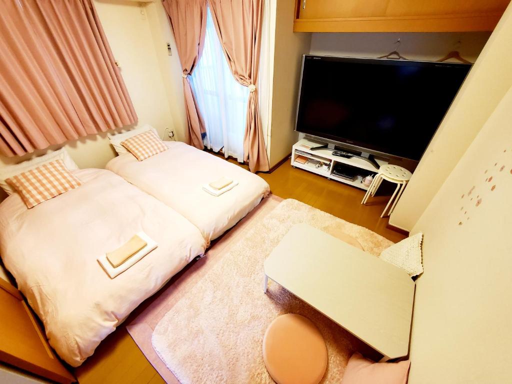 Habitación pequeña con 2 camas y TV de pantalla plana. en Takaraboshi room 301 Sannomiya 10 min en Kobe
