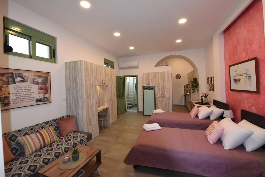 een woonkamer met 2 bedden en een bank bij Lolos' house in Rhodos-stad