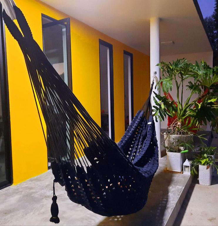 a black hammock hanging in front of a house at CASA NOVA 2 in São José da Coroa Grande